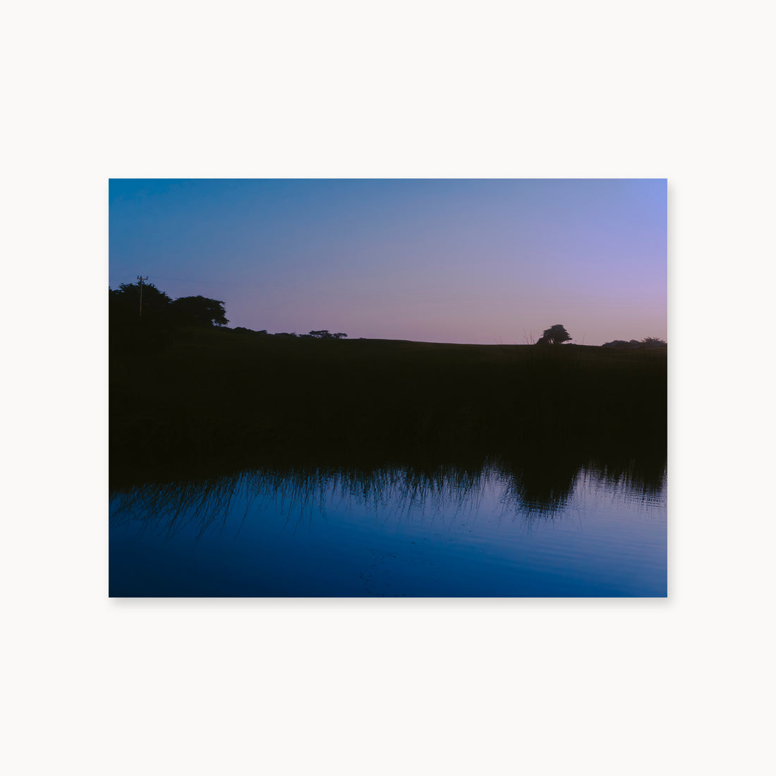 
What Lays Beneath — 30x40, unframed. Dark trees and a twilight shoreline reflected across blue water.