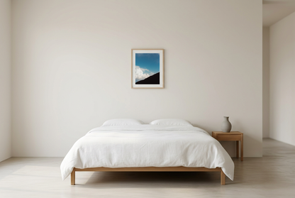 This minimalist mountain wall art features a blue sky landscape with a subtle human silhouette, creating a calm and reflective atmosphere. Perfect for modern and Scandinavian interiors, it adds depth and quiet elegance to any room.