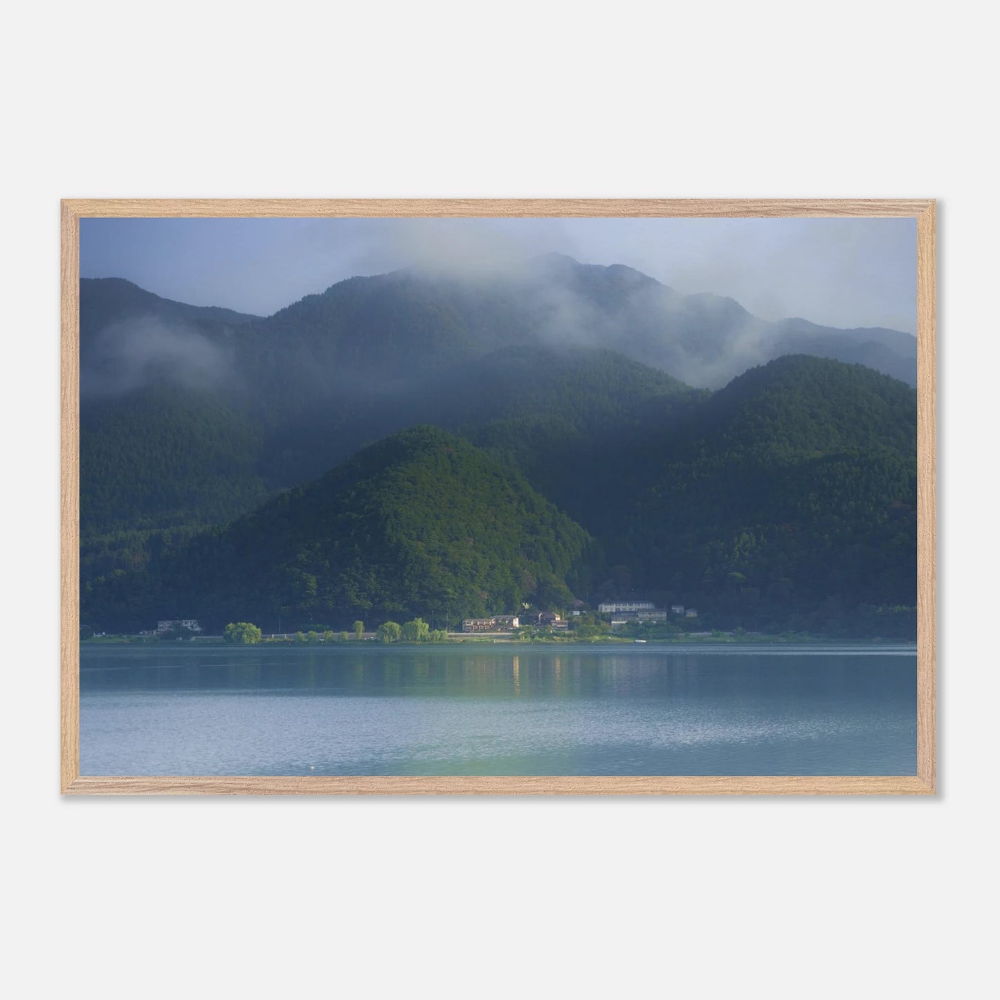 This misty lake mountain landscape wall art print captures serene blue tones and tranquil natural scenery, making it ideal for minimalist home decor. Designed for calming interiors, this fine art nature photography print enhances spaces with peaceful lake reflections, foggy mountain layers, and soft atmospheric light. A perfect choice for those seeking calming wall art, nature-inspired decor, or serene landscape prints for modern homes.