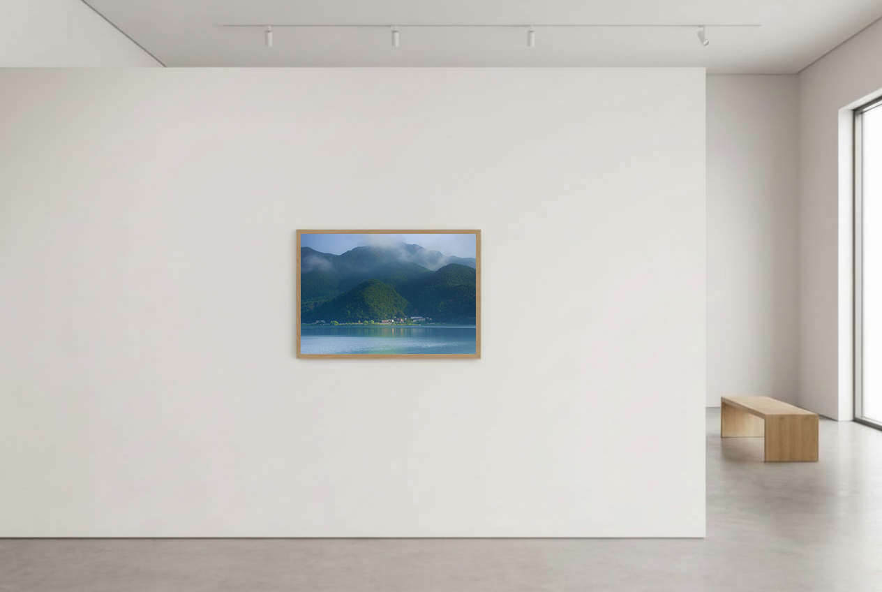 This misty lake mountain landscape wall art print captures serene blue tones and tranquil natural scenery, making it ideal for minimalist home decor. Designed for calming interiors, this fine art nature photography print enhances spaces with peaceful lake reflections, foggy mountain layers, and soft atmospheric light. A perfect choice for those seeking calming wall art, nature-inspired decor, or serene landscape prints for modern homes.