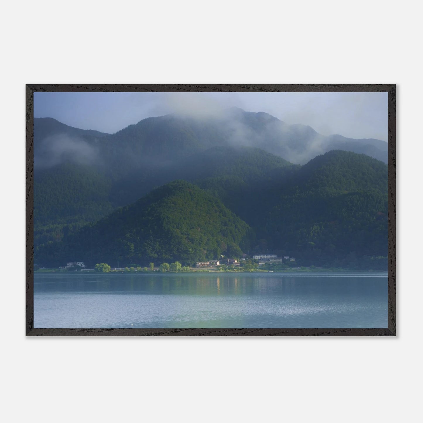 This misty lake mountain landscape wall art print captures serene blue tones and tranquil natural scenery, making it ideal for minimalist home decor. Designed for calming interiors, this fine art nature photography print enhances spaces with peaceful lake reflections, foggy mountain layers, and soft atmospheric light. A perfect choice for those seeking calming wall art, nature-inspired decor, or serene landscape prints for modern homes.