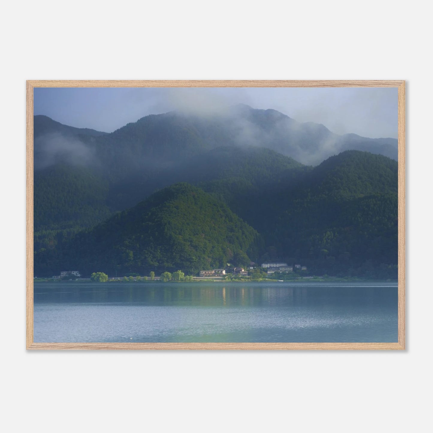 This misty lake mountain landscape wall art print captures serene blue tones and tranquil natural scenery, making it ideal for minimalist home decor. Designed for calming interiors, this fine art nature photography print enhances spaces with peaceful lake reflections, foggy mountain layers, and soft atmospheric light. A perfect choice for those seeking calming wall art, nature-inspired decor, or serene landscape prints for modern homes.