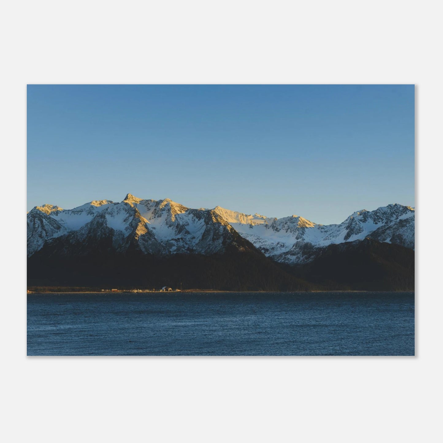 This calming mountain and ocean wall art print features a minimalist landscape with blue tones and soft natural light. 