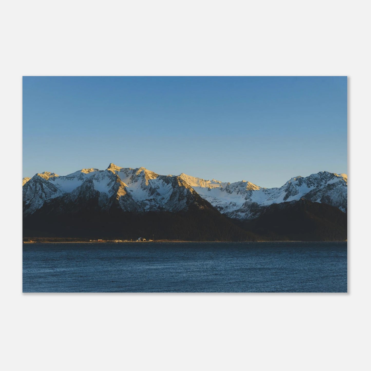 This calming mountain and ocean wall art print features a minimalist landscape with blue tones and soft natural light. 