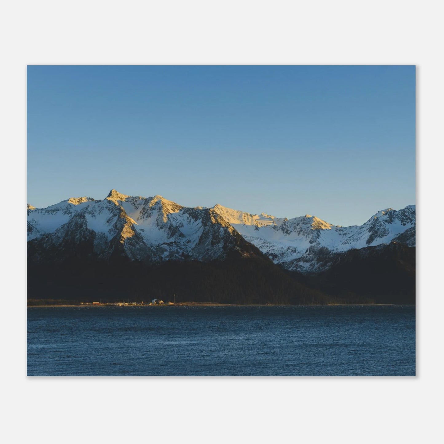 This calming mountain and ocean wall art print features a minimalist landscape with blue tones and soft natural light. 