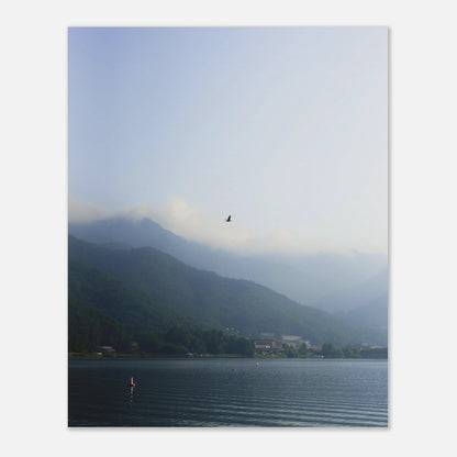 This minimalist mountain lake photography print features a serene blue-toned landscape with a bird in flight, making it ideal for calm wall art, Japandi decor, and modern minimalist interiors. Perfect for living rooms, bedrooms, and offices, this fine art print enhances spaces with soft blue hues, atmospheric depth, and a peaceful, elevated aesthetic.