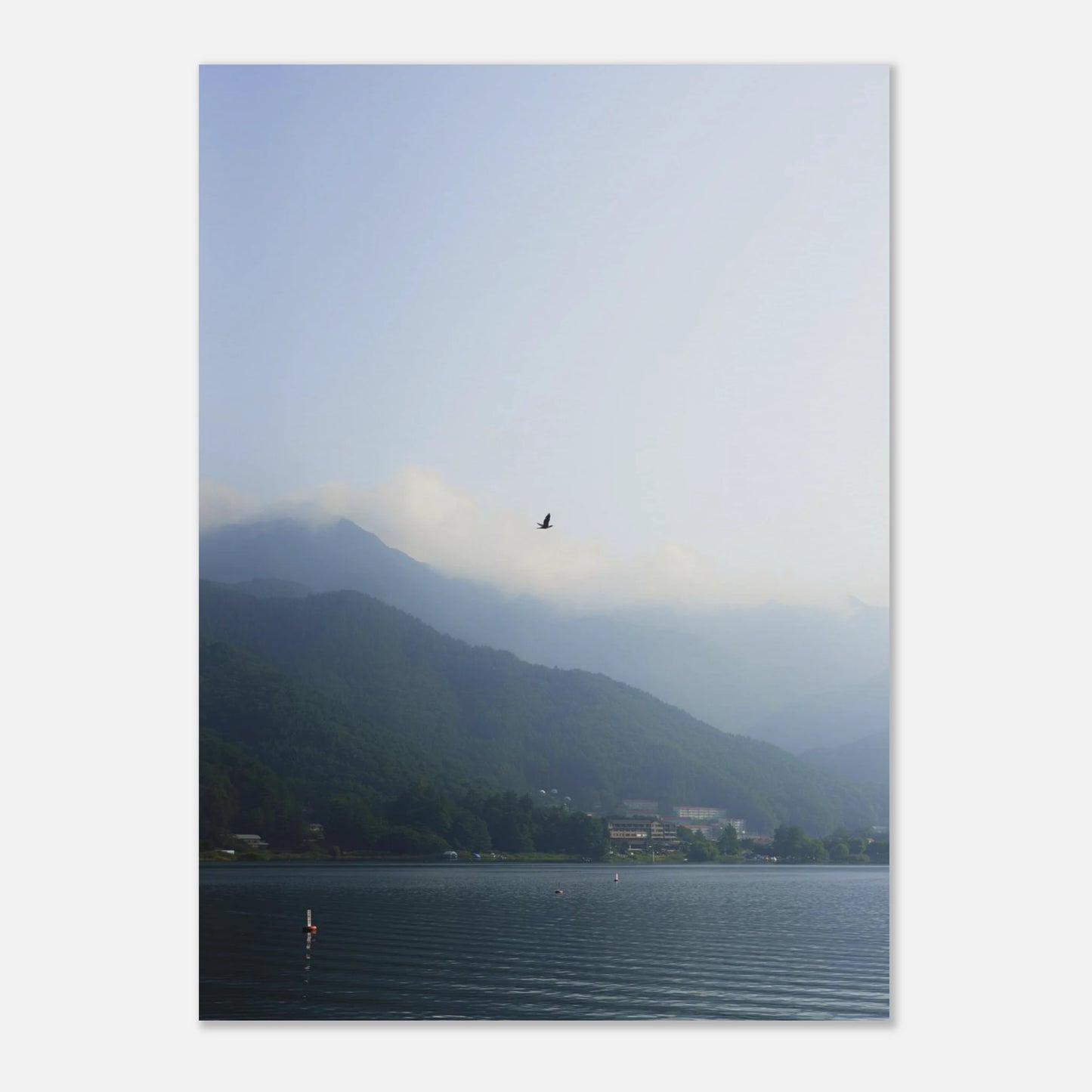 This minimalist mountain lake photography print features a serene blue-toned landscape with a bird in flight, making it ideal for calm wall art, Japandi decor, and modern minimalist interiors. Perfect for living rooms, bedrooms, and offices, this fine art print enhances spaces with soft blue hues, atmospheric depth, and a peaceful, elevated aesthetic.