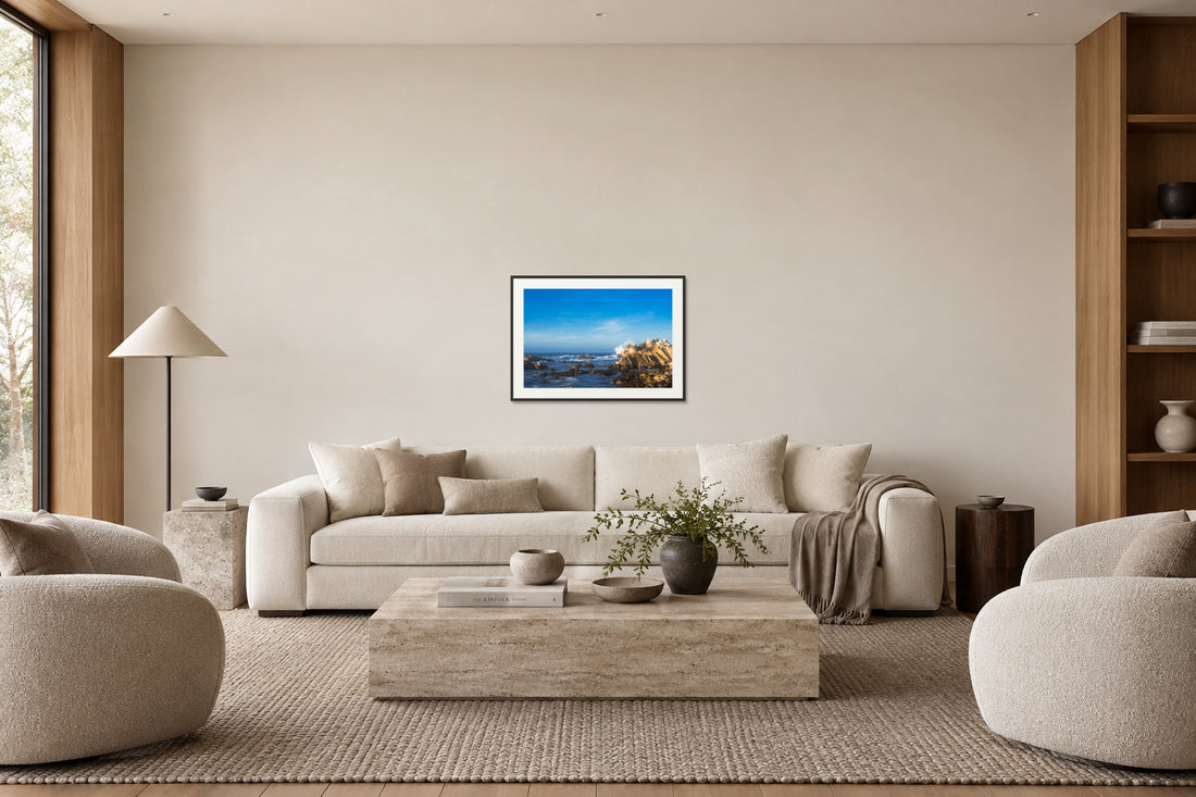 Collector framed coastal artwork above the same sofa